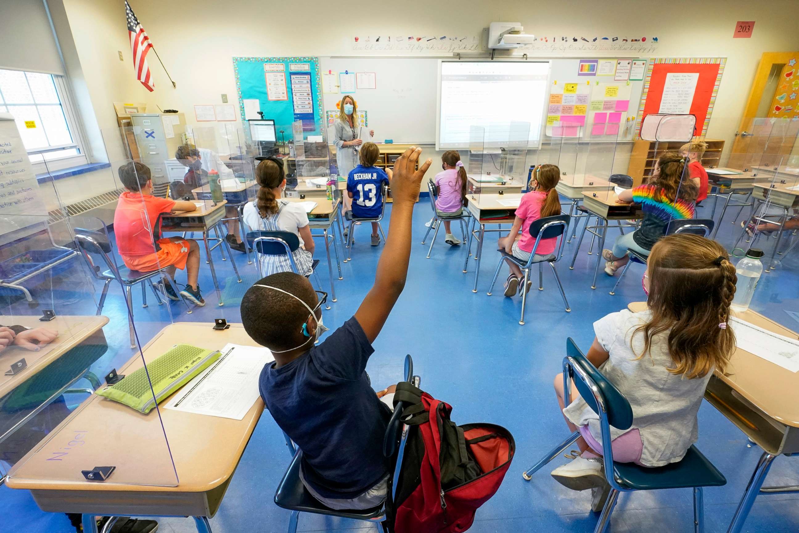 PHOTO: In this May 18, 2021, file photo, a teacher, center, and her third grade students wear face masks and are seated at proper social distancing spacing during as she conducts her class in Rye, N.Y. 