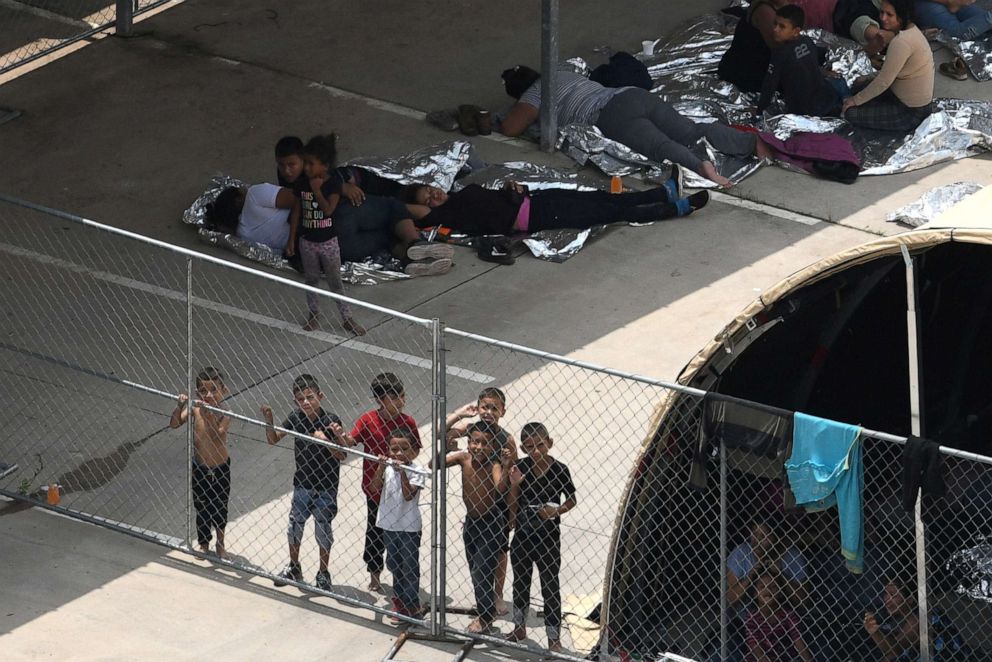 PHOTO: At a nearby facility to the Central Processing Center where a suspected flu outbreak has prompted officials to stop processing, migrants look out from a makeshift encampment at the U.S. Border Patrol McAllen Station in McAllen, Texas, May 15, 2019.