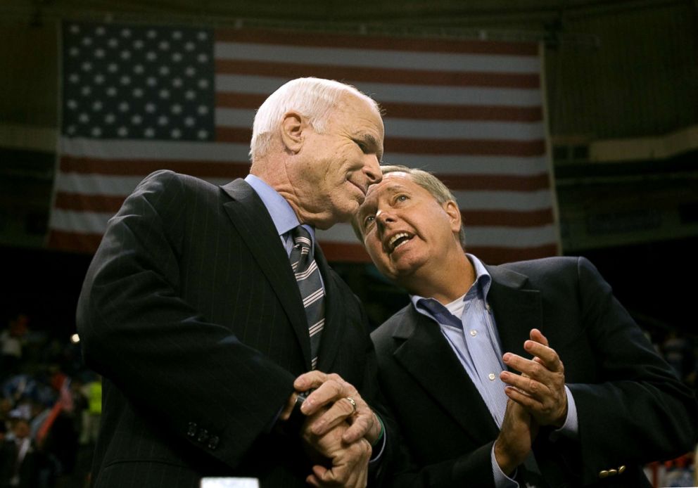 PHOTO: Sen. Lindsey Graham, right, leans in for a private remark to Sen. John McCain during the start of a rally at the Crown Center in Fayetteville, North Carolina, Oct. 28, 2008.