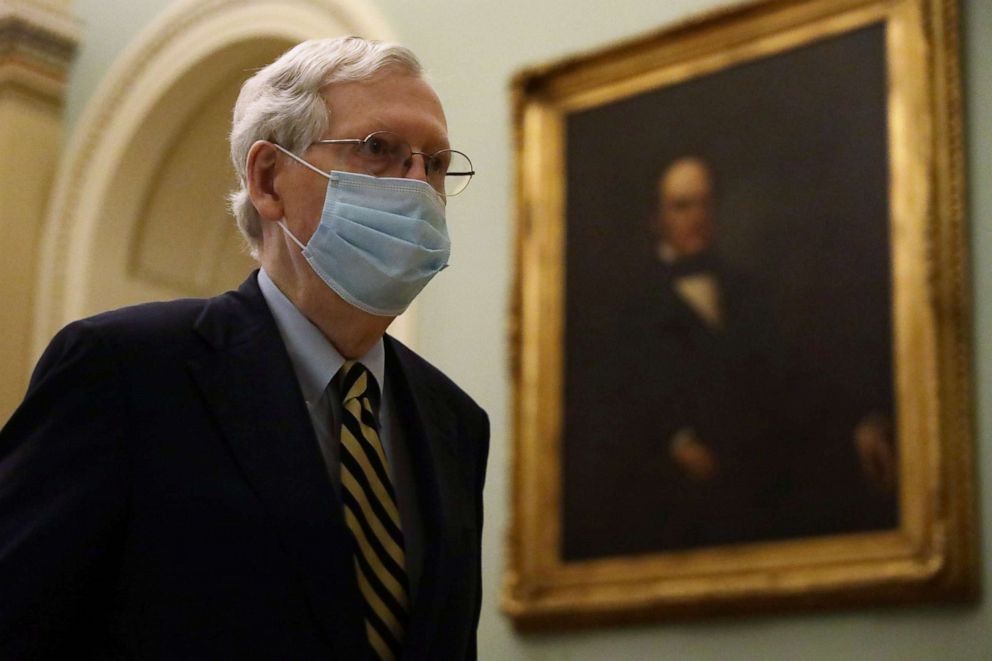 PHOTO: Senate Majority Leader Sen. Mitch McConnell wears a mask as he walks through a hallway at the Capitol, May 11, 2020 in Washington.