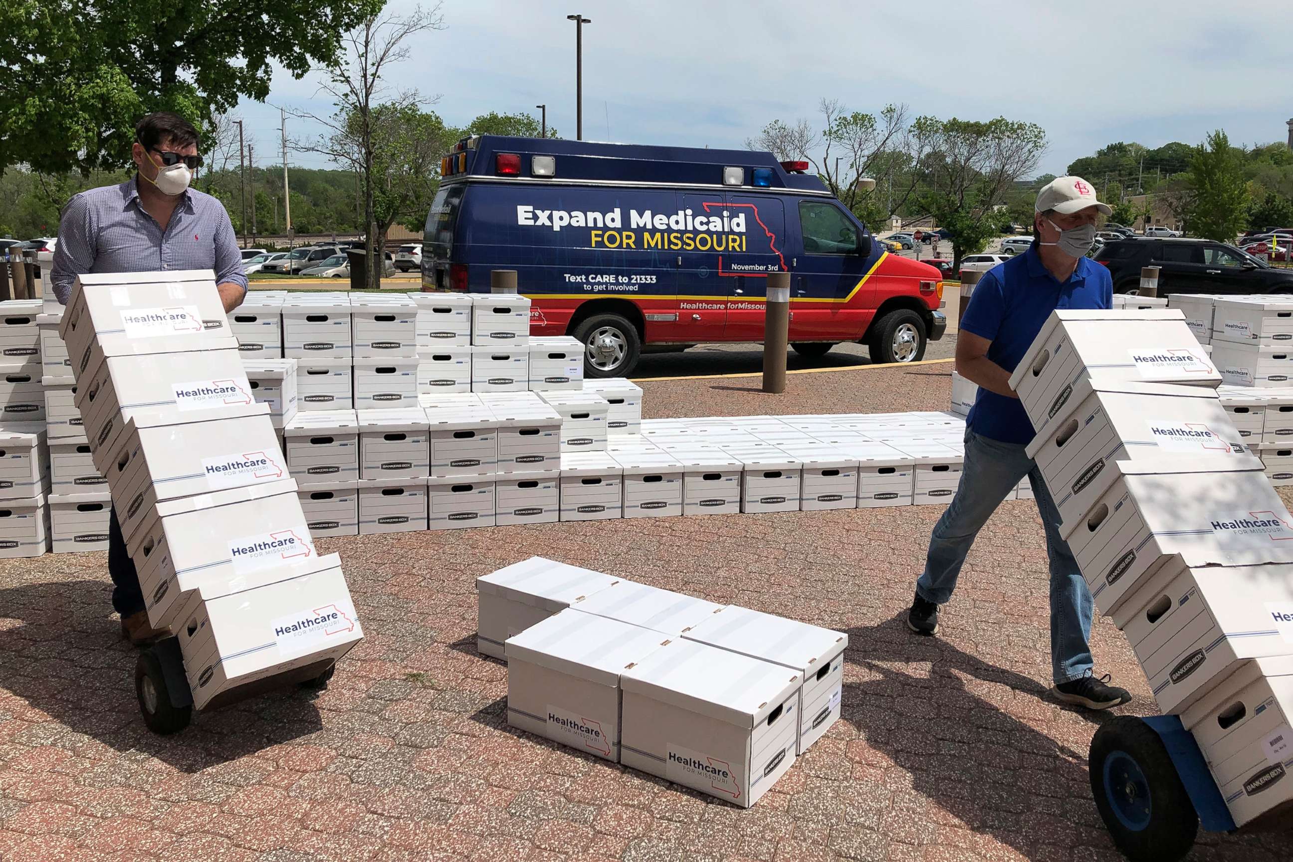 PHOTO: Campaign workers David Woodruff, left, and Jason White, right, deliver boxes of initiative petitions signatures to the Missouri secretary of state's office in Jefferson City, Mo., May 1, 2020.