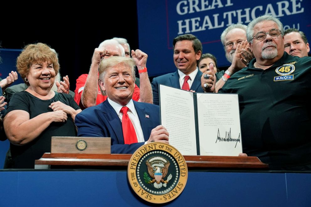 PHOTO: President Donald Trump holds up an executive order on Medicare he signed during an event at The Villages retirement community in The Villages, Florida, Oct. 3, 2019.