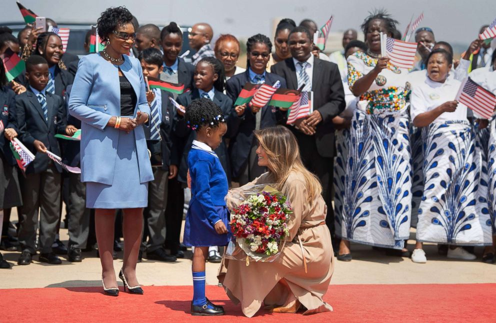 PHOTO: First lady Melania Trump receives flowers from a young girl alongside the first lady of Malawi, Gertrude Mutharika, left, upon her arrival at Lilongwe International Airport, Oct. 4, 2018 as part of her week long trip to Africa.