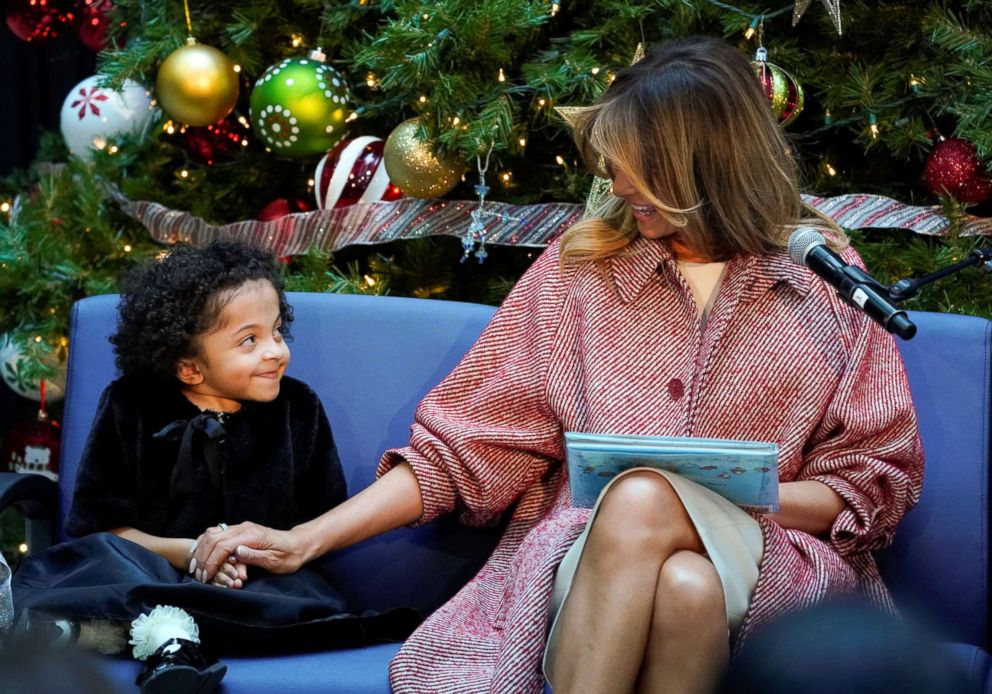 PHOTO: First lady Melania Trump reaches out to Tearrianna Cooke-Starkey while reading a children's Christmas story during her visit to Children's National Health System in Washington, DC, Dec. 13, 2018.