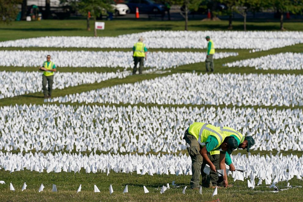 PHOTO: Workers plant white flags as part of artist Suzanne Brennan Firstenberg's temporary art installation, &quot;In America: Remember,&quot; in remembrance of Americans who have died of COVID-19, on the National Mall in Washington, Sept. 15, 2021.