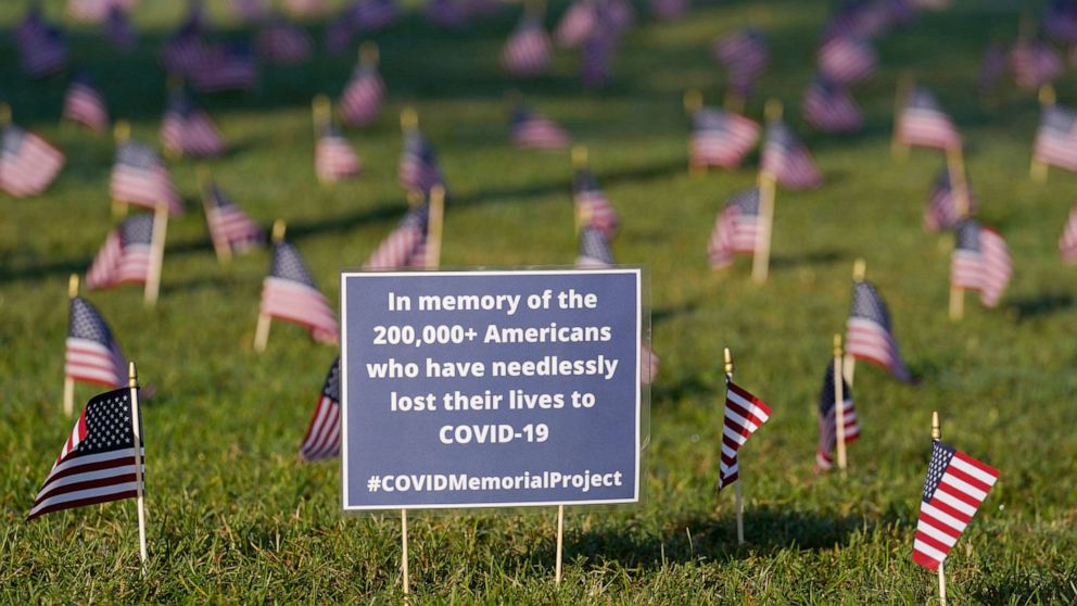 PHOTO: Activists from the COVID Memorial Project mark the deaths of 200,000 lives lost in the U.S. to COVID-19 after placing thousands of small American flags places on the grounds of the National Mall in Washington, Sept. 22, 2020.