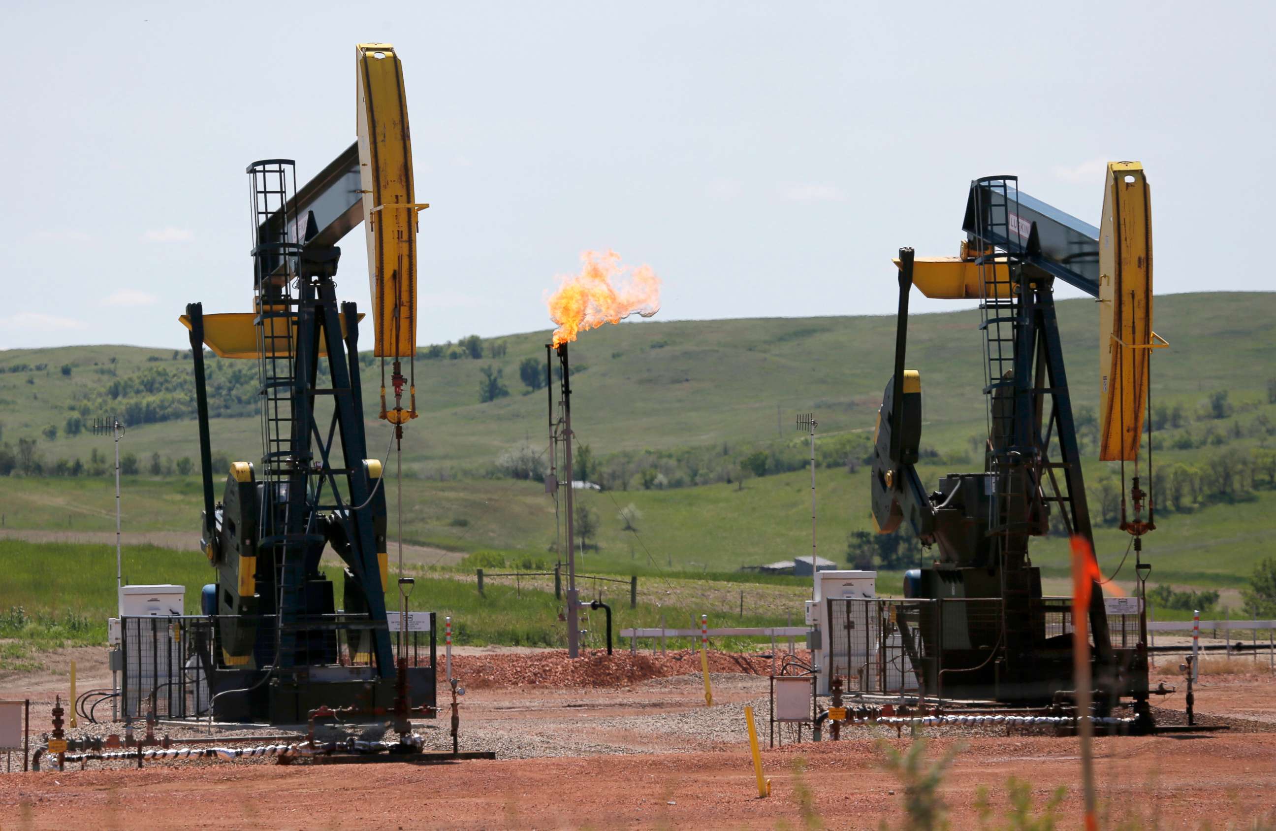 PHOTO: Natural gas is burned off near pumps in Watford City, N.D., June 12, 2014.