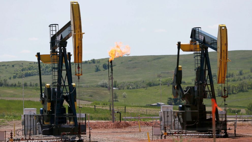 PHOTO: Natural gas is burned off near pumps in Watford City, N.D., June 12, 2014.