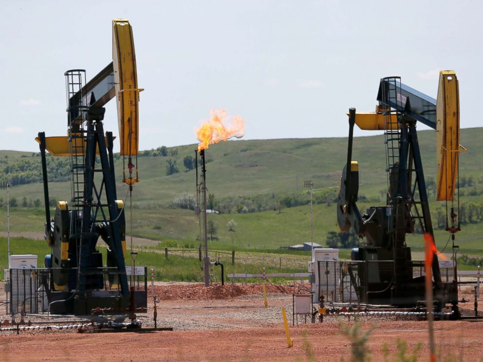 PHOTO: Natural gas is burned off near pumps in Watford City, N.D., June 12, 2014.