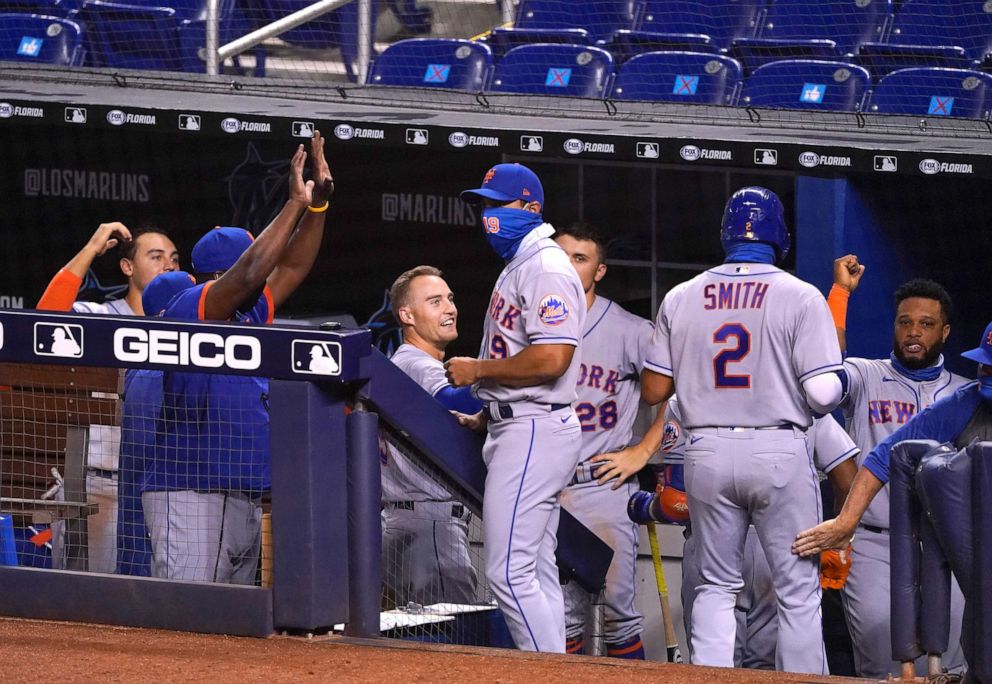 PHOTO: The New York Mets celebrate in the dugout after Dominic Smith #2 of the New York Mets scores in the eighth inning against the Miami Marlins at Marlins Park, Aug. 19, 2020, in Miami.