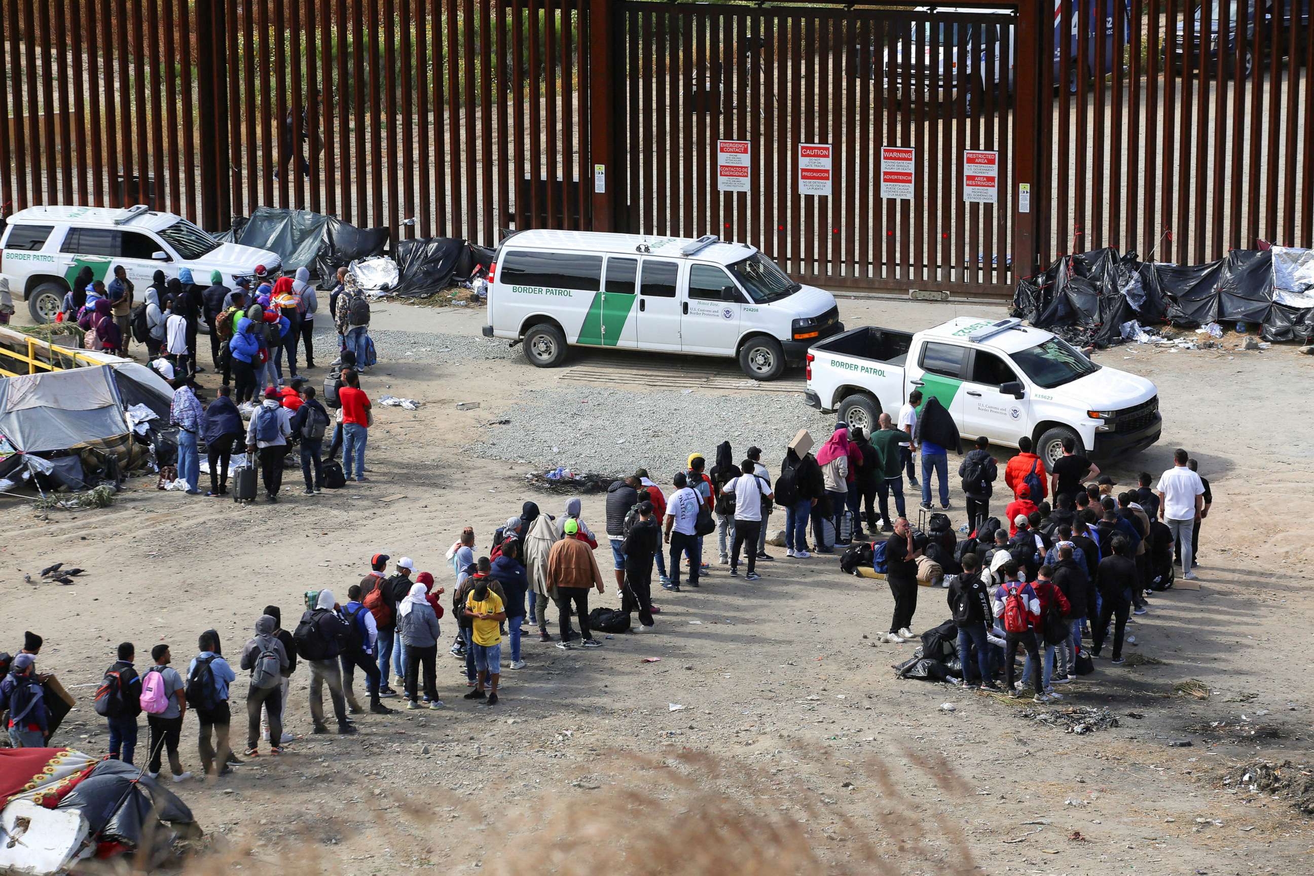 PHOTO: Migrants gather between the primary and secondary border fences in San Diego as the United States prepares to lift COVID-19-era restrictions known as Title 42 as seen from Tijuana, Mexico, May 8, 2023.