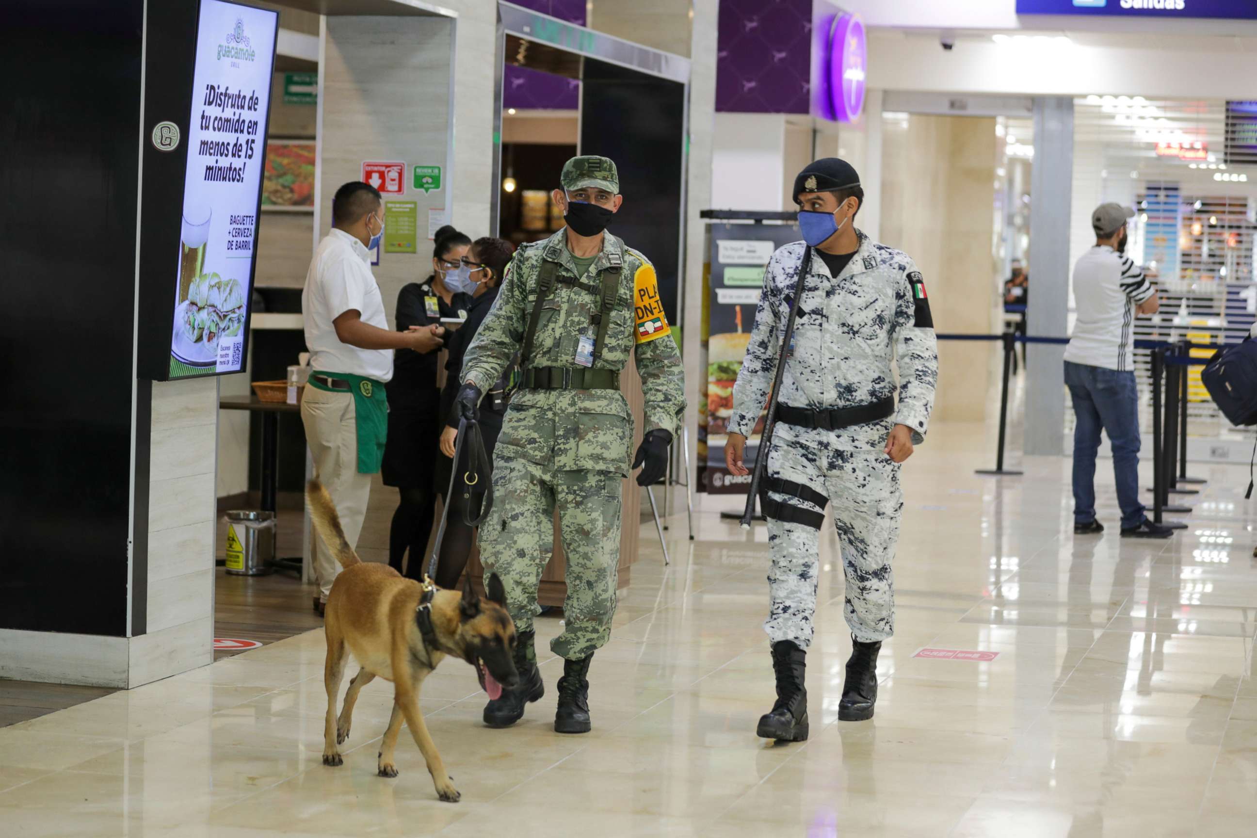PHOTO: Members of the military make sure passengers are following the COVID-19 rules at Cancun International Airport on Nov. 19, 2020 in Cancun, Mexico.
