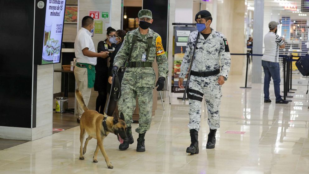 PHOTO: Members of the military make sure passengers are following the COVID-19 rules at Cancun International Airport on Nov. 19, 2020 in Cancun, Mexico.