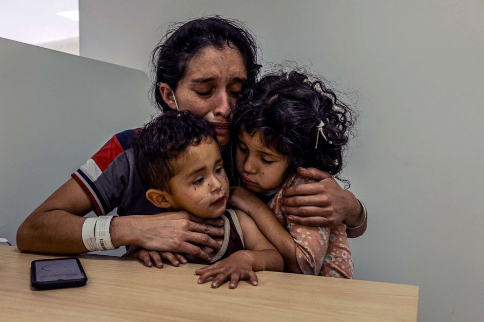 PHOTO: Vilma Iris Peraza, a migrant from Honduras, embraces her two children in Ciudad Juarez, Mexico, March 18, 2021, after they were deported from El Paso, Texas.