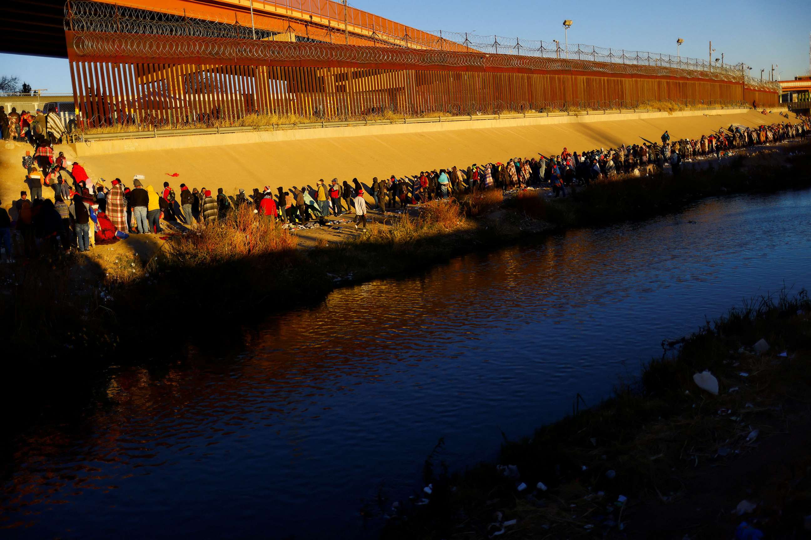 PHOTO: Migrants queue near the border wall after crossing the Rio Bravo river to turn themselves in to U.S. Border Patrol agents to request asylum in the U.S. city of El Paso, Texas, as seen from Ciudad Juarez, Mexico, on Dec. 14, 2022.