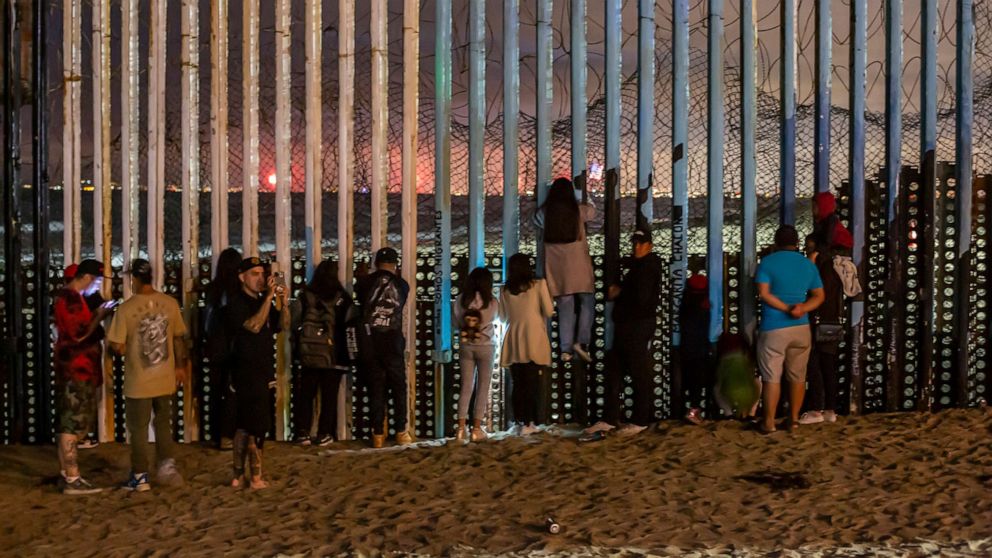 PHOTO: Hundreds of people watch from the border fence in Playas de Tijuana, Mexico, as U.S. Independence Day fireworks were launched several miles away in San Diego Bay, Calif., July 4, 2022.