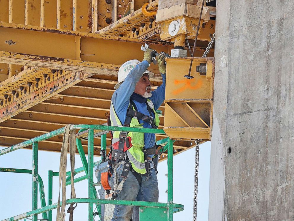 PHOTO: A construction worker builds the Signature Bridge, replacing and improving a busy intersection at I-95 and I-395 on March 17, 2021 in Miami. The infrastructure project will ease traffic congestion and connect communities with downtown neighborhoods