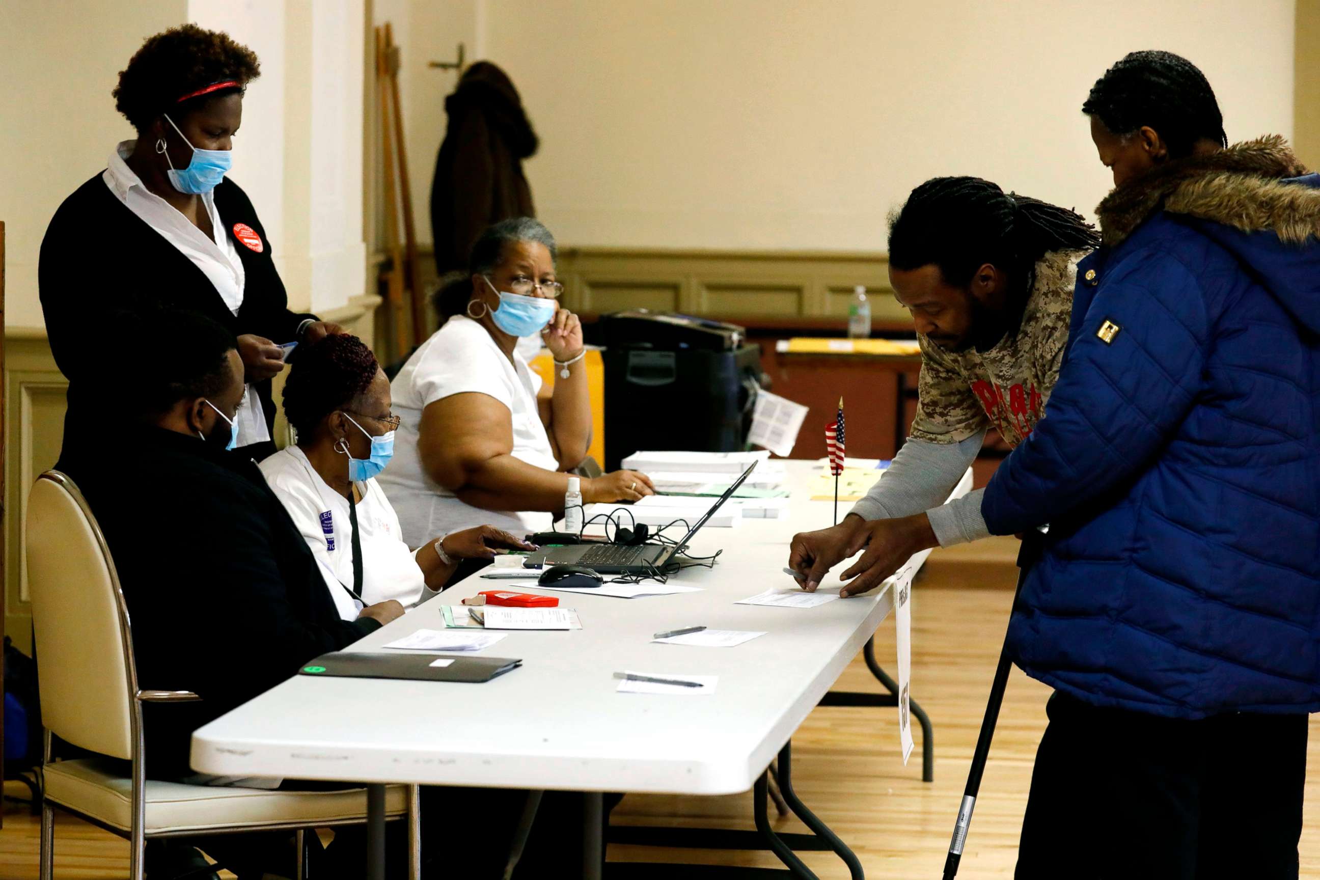 PHOTO: Election workers wear protective face masks as they check voters to get their to vote in the Michigan primary election at Central United Methodist Church in Detroit, March 10, 2020. 