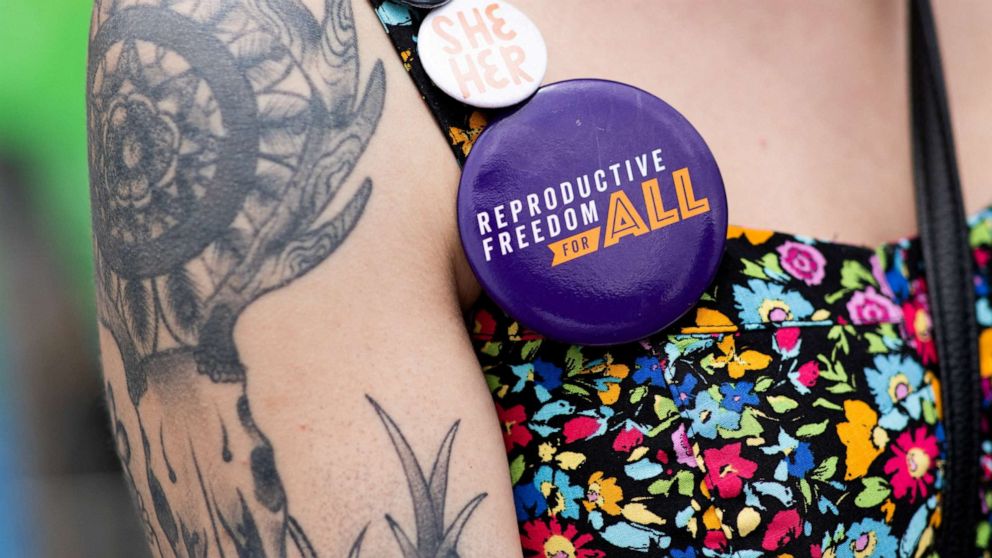 PHOTO: A volunteer wears pins as she gathers signatures for a proposed abortion amendment at Ferndale Pride in Ferndale, Mich., June 4, 2022.
