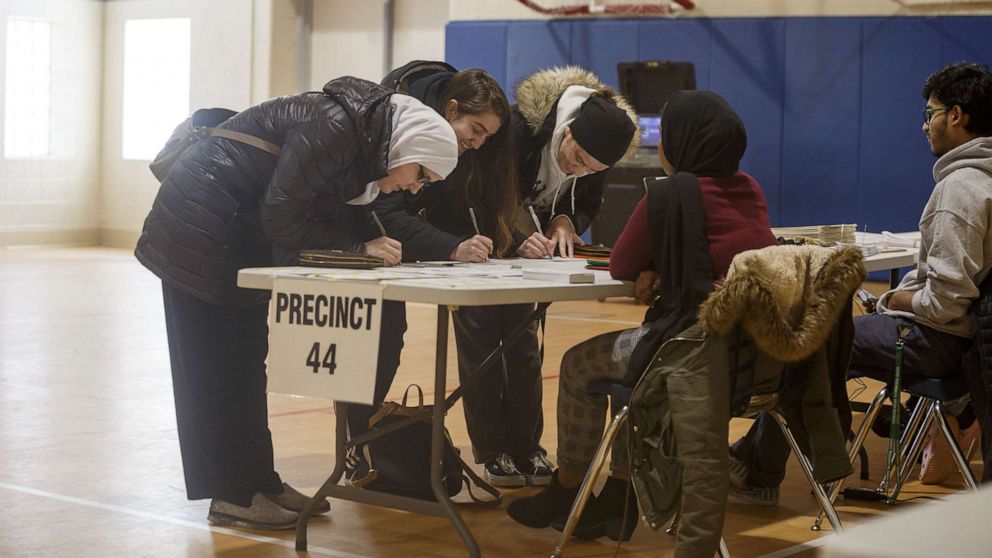 PHOTO: Azemina Hodzic prepares to vote with her two daughters, Amra Hodzic and Lejla Hodzic at a polling place at Cromie Elementary School on March 10, 2020, in Warren, Mic.