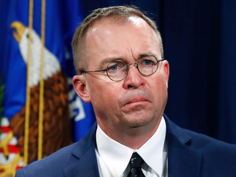 PHOTO: Mick Mulvaney, Acting Director of the Office of Consumer Financial Protection (CFPB) and Director of the Office of Management, listens to a press conference at the Department of Justice in Washington on July 11, 2018.