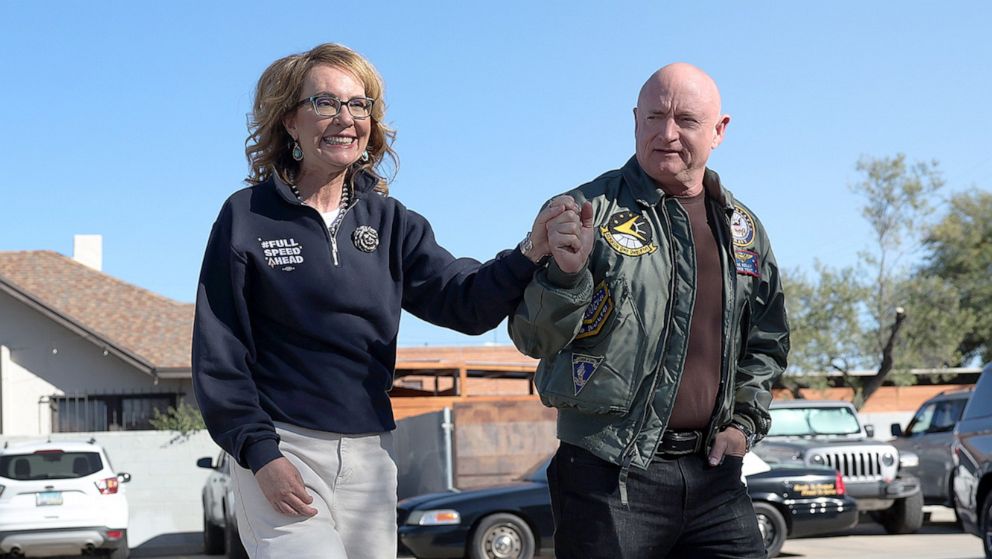 PHOTO: Sen. Mark Kelly and his wife former Rep. Gabby Giffords talk to campaign volunteers on Election Day in Tuscon, Ariz., Nov. 08, 2022.