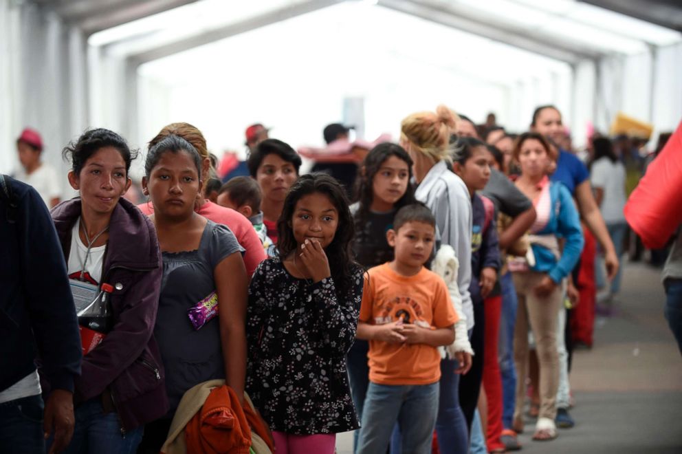 PHOTO: Central American migrants taking part in a caravan heading to the US, line up to borrow a sleeping pad, after arriving at a temporary shelter, set up in a stadium in Mexico City, Nov. 5, 2018.