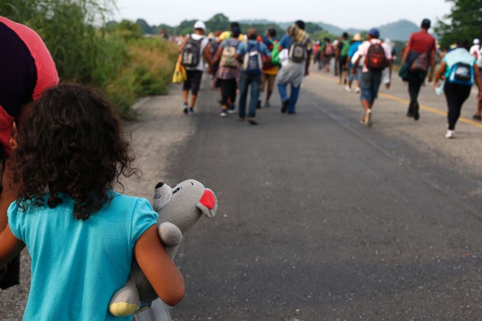 PHOTO: A girl carries a stuffed teddy bear as she walks with her mother with a migrant caravan near Arriaga, Chiapas state, Mexico, Oct. 27, 2018.