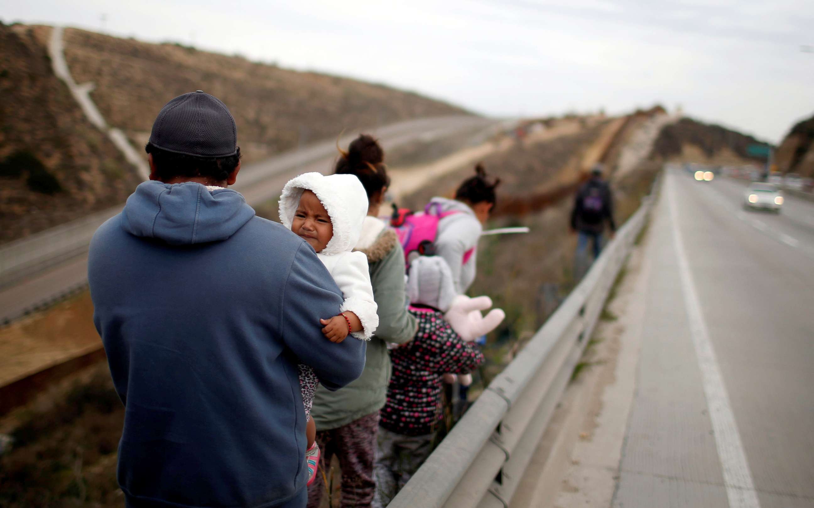 PHOTO: Migrants from Honduras, part of a caravan of thousands from Central America trying to reach the United States, walk next to the border fence as they prepare to cross it illegally in Tijuana, Mexico, Dec. 14, 2018.
