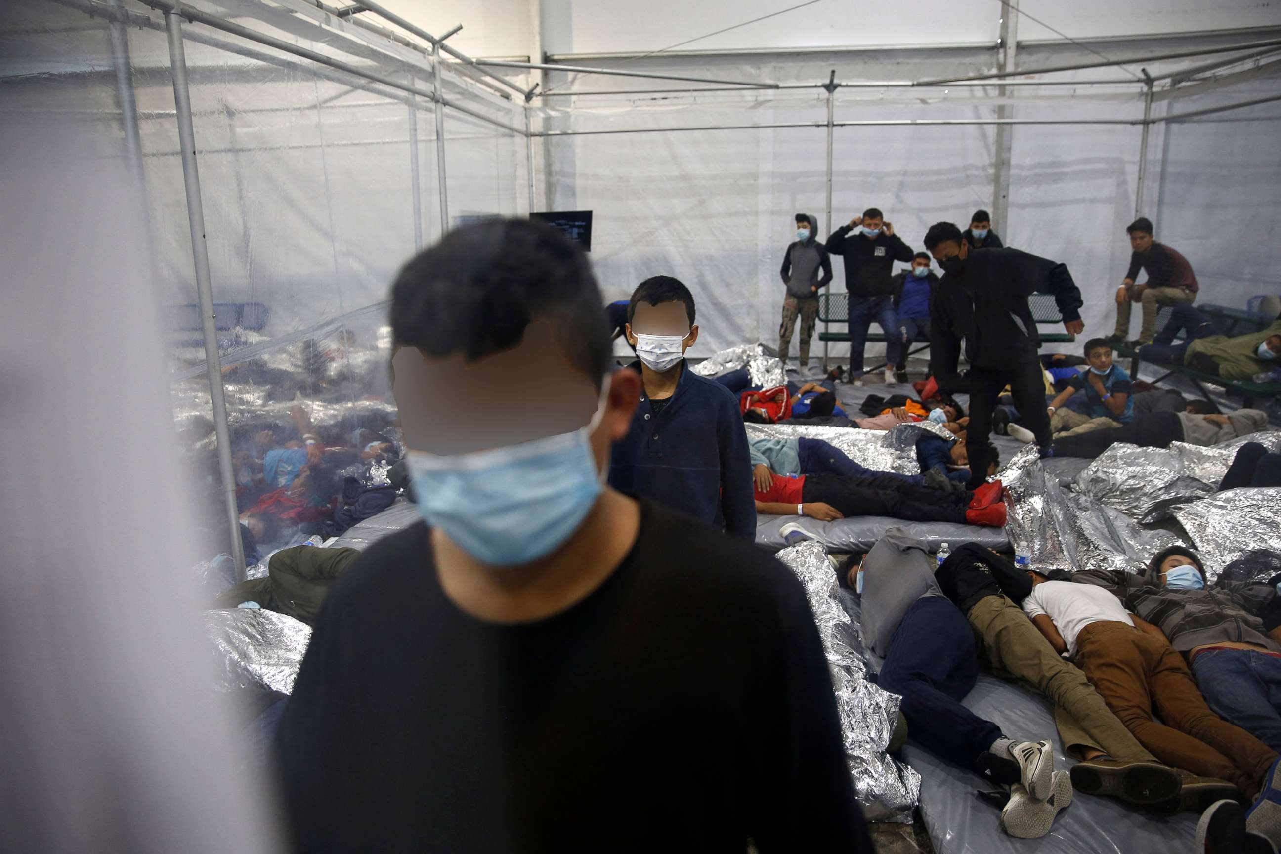 PHOTO: Young children stand as other rest at the Donna Department of Homeland Security holding facility, the main detention center for unaccompanied children in the Rio Grande Valley run by the Customs and Border Patrol, in Donna, Texas, March 30, 2021. 