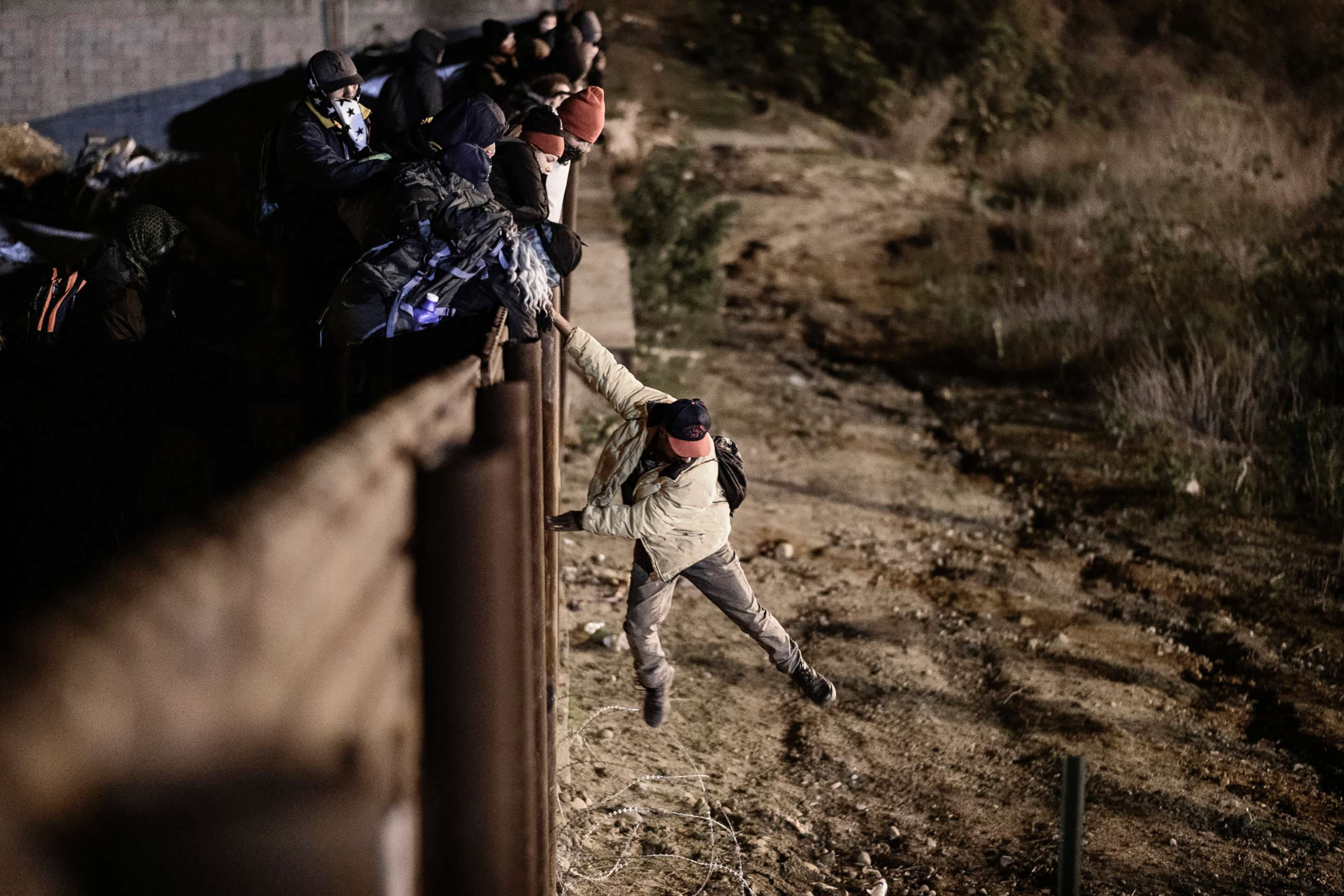 PHOTO: A migrant jumps the border fence to get into the U.S. from Tijuana, Mexico, Jan. 1, 2019.