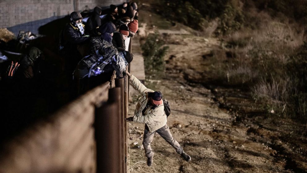 PHOTO: A migrant jumps the border fence to get into the U.S. from Tijuana, Mexico, Jan. 1, 2019.