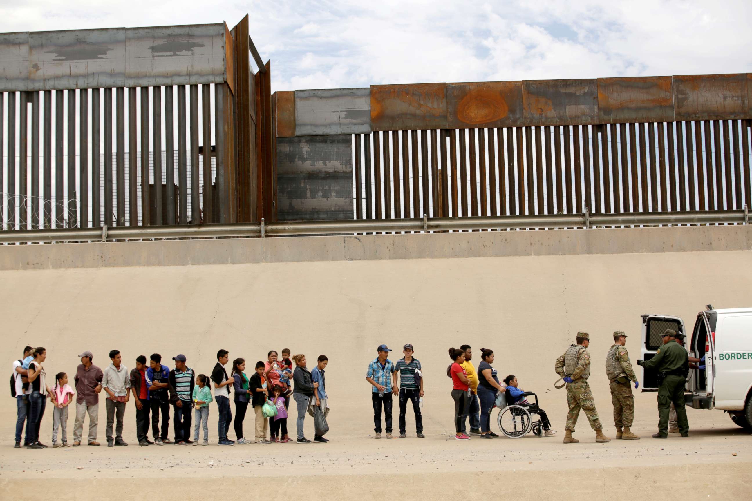 PHOTO: Members of the Border Patrol and U.S. Military help a migrant woman in a wheelchair as she and others migrants illegally crossed the border between Mexico and the U.S. to request political asylum, as seen from Ciudad Juarez, Mexico, July 6, 2019.