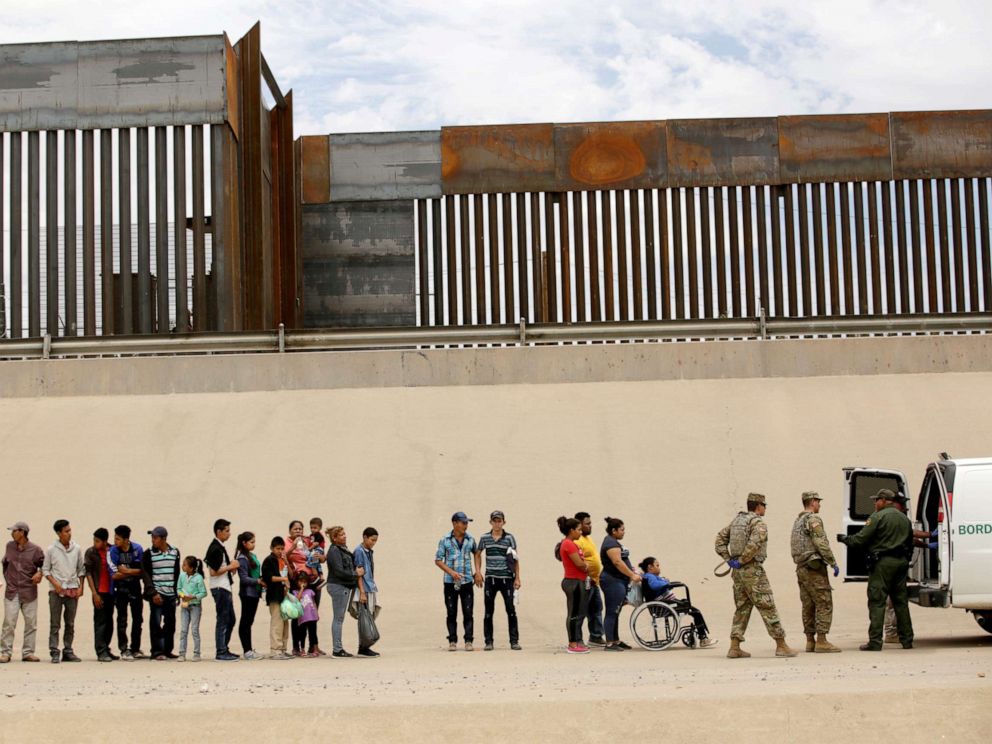 PHOTO: Members of the Border Patrol and U.S. Military help a migrant woman in a wheelchair as she and others migrants illegally crossed the border between Mexico and the U.S. to request political asylum, as seen from Ciudad Juarez, Mexico, July 6, 2019.