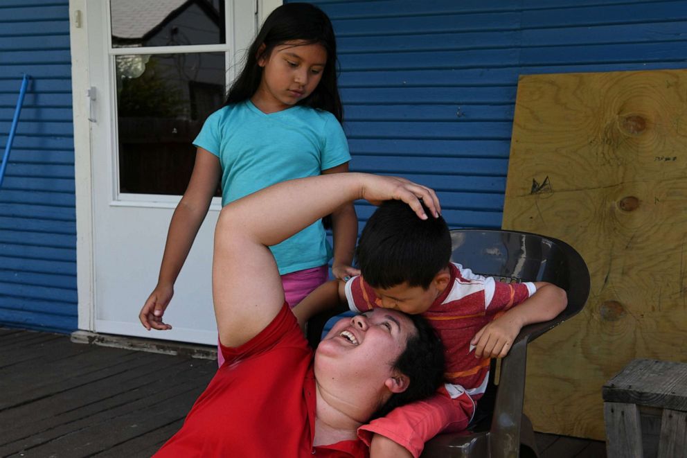 PHOTO: In this June 6, 2019, file photo, Irma Rivera, an asylum-seeker from Honduras, spends time with her children after  getting home from work in Fort Worth, Texas.