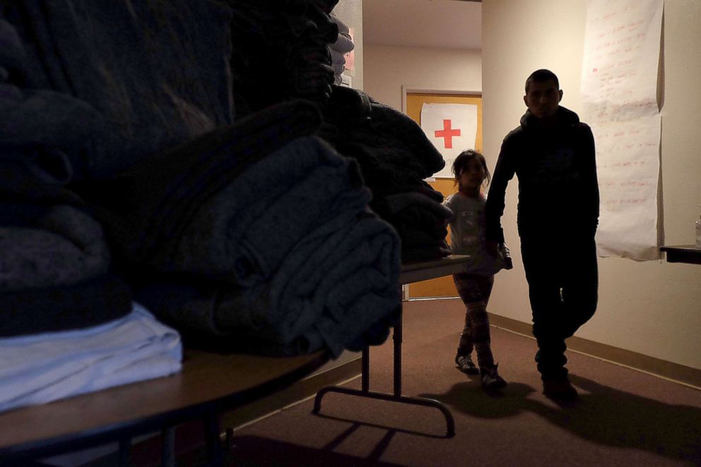 PHOTO: A father and daughter from Guatemala walk throug the temporary shelter organized by the San Diego Rapid Response Network, in San Diego, Calif. 