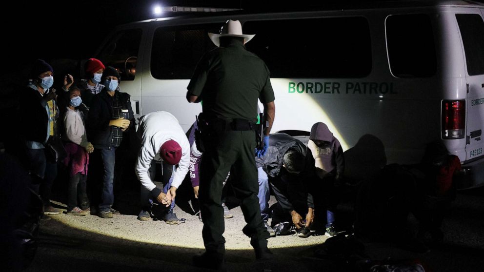 PHOTO: A group of migrants is processed by U.S. Border Patrol agents after arriving from Mexico on March 30, 2021 in Roma, Texas.
