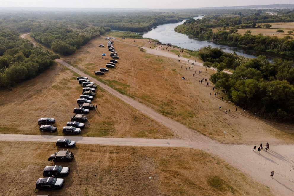 PHOTO: Official vehicles line up along the bank of the Rio Grande near an encampment of migrants, many from Haiti, near the Del Rio International Bridge, Sept. 21, 2021, in Del Rio, Texas.