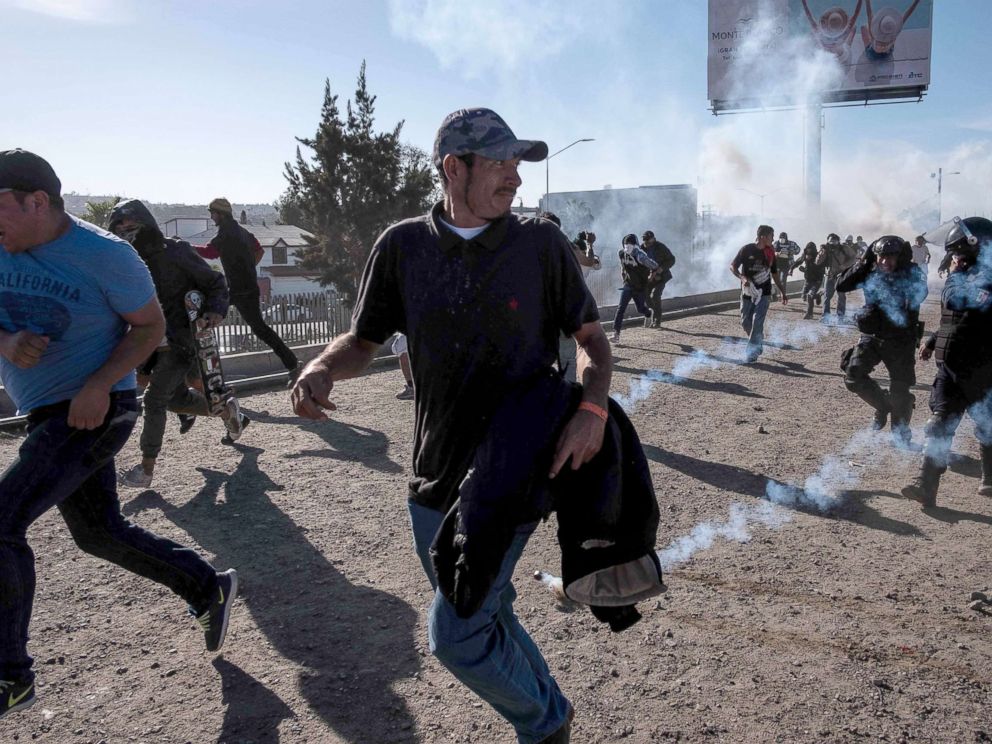 PHOTO: Central American migrants run along the Tijuana River near the El Chaparral border crossing in Tijuana after the US border patrol threw tear gas to disperse them, Nov. 25, 2018.
