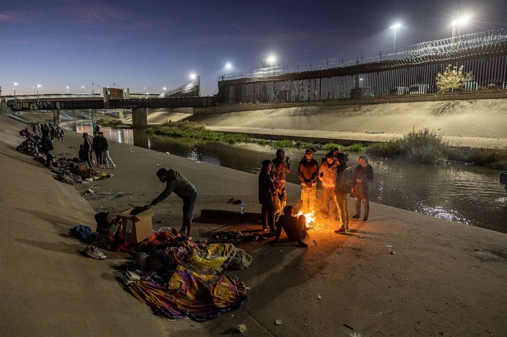 PHOTO: Migrants spend the night outside, near the U.S.-Mexico border fence while waiting to make asylum claims in El Paso, Texas on Dec. 21, 2022 as seen from Ciudad Juarez, Mexico.