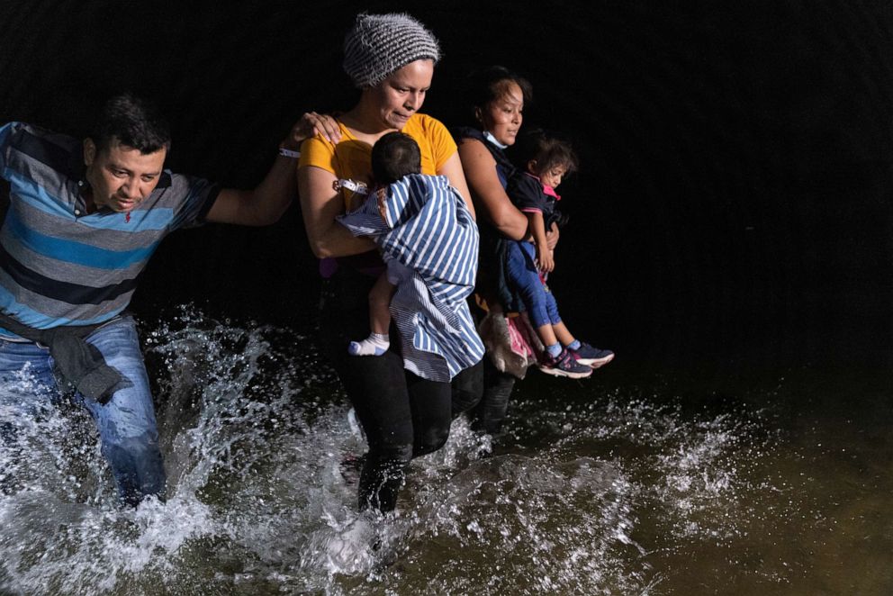 PHOTO: A family from El Salvador walks ashore to the bank of the Rio Grande at the U.S.-Mexico border on April 14, 2021, in Roma, Texas.