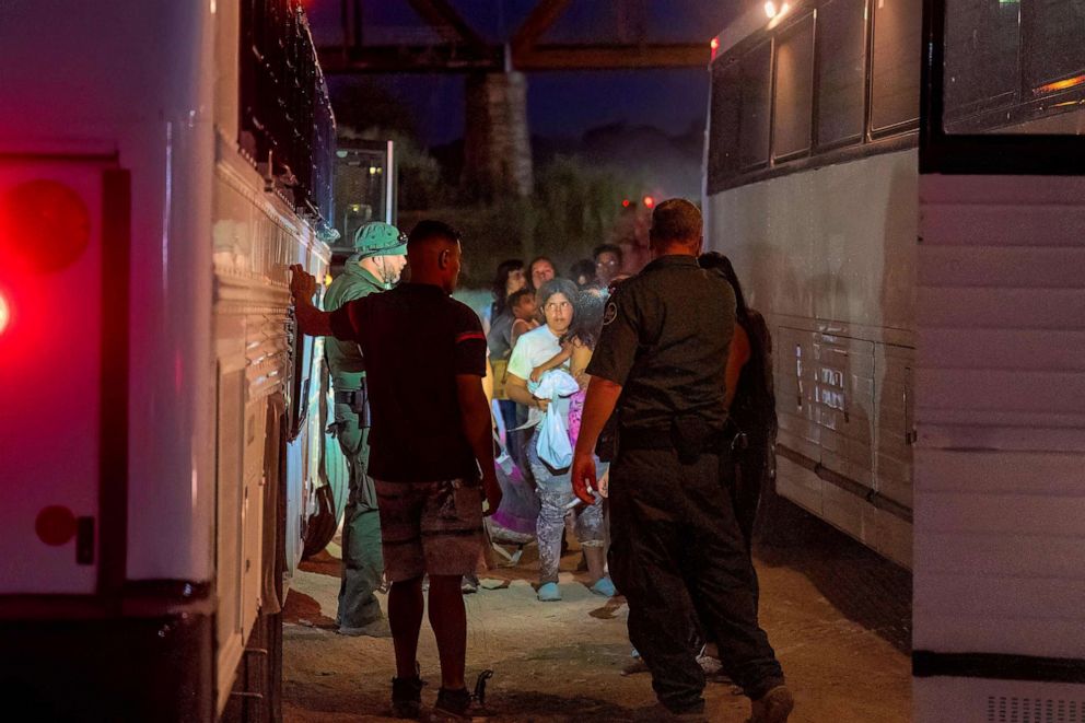 PHOTO: Border Patrol agents escort migrants onto a bus to be taken to a processing facility to begin their asylum-seeking process in Eagle Pass, Texas on June 25, 2023.