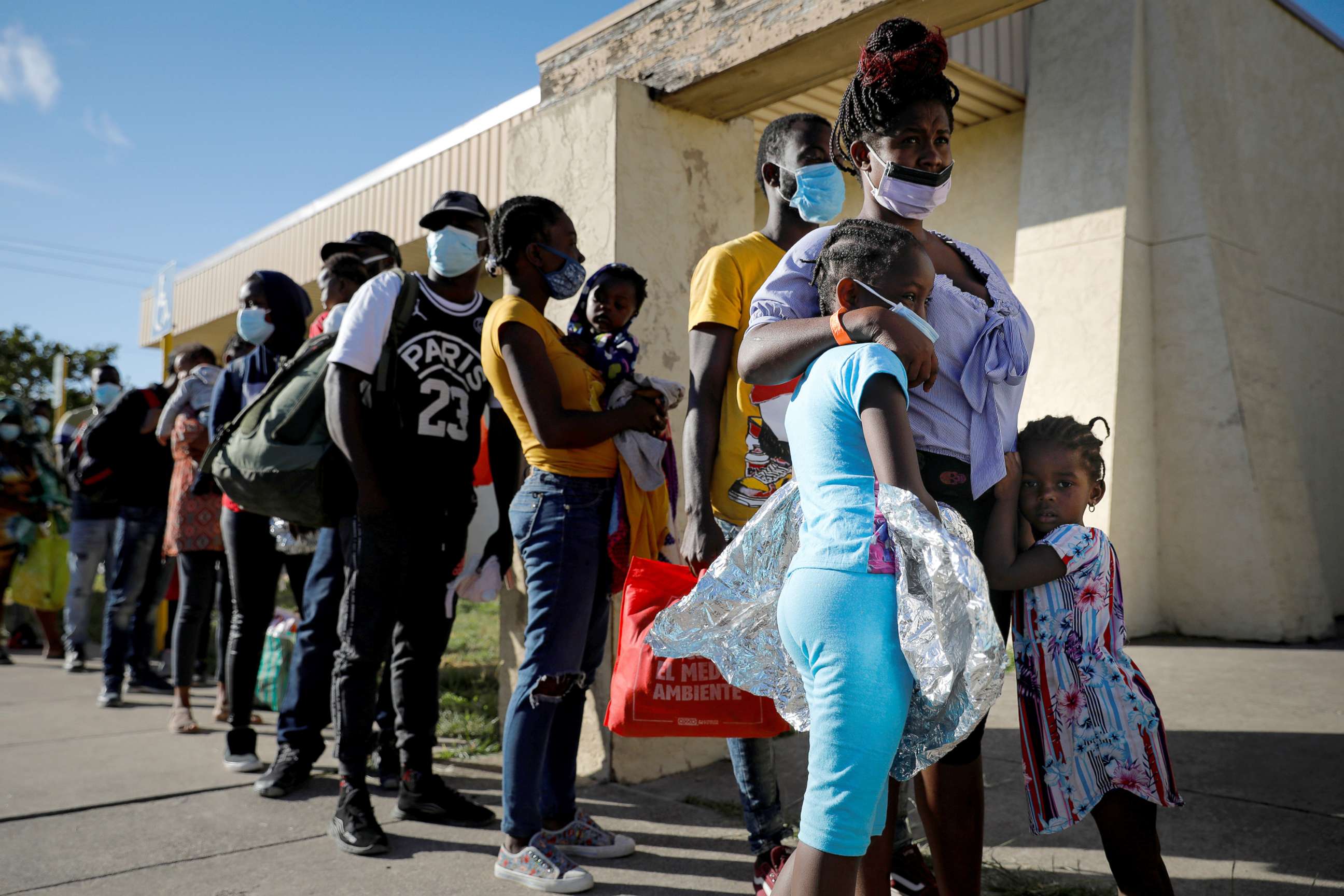 PHOTO: Migrants seeking asylum in the U.S. wait in line to board a bus to Houston from Val Verde Border Humanitarian Coalition after being released from U.S. Customs and Border Protection, in Del Rio, Texas, Sept. 24, 2021.