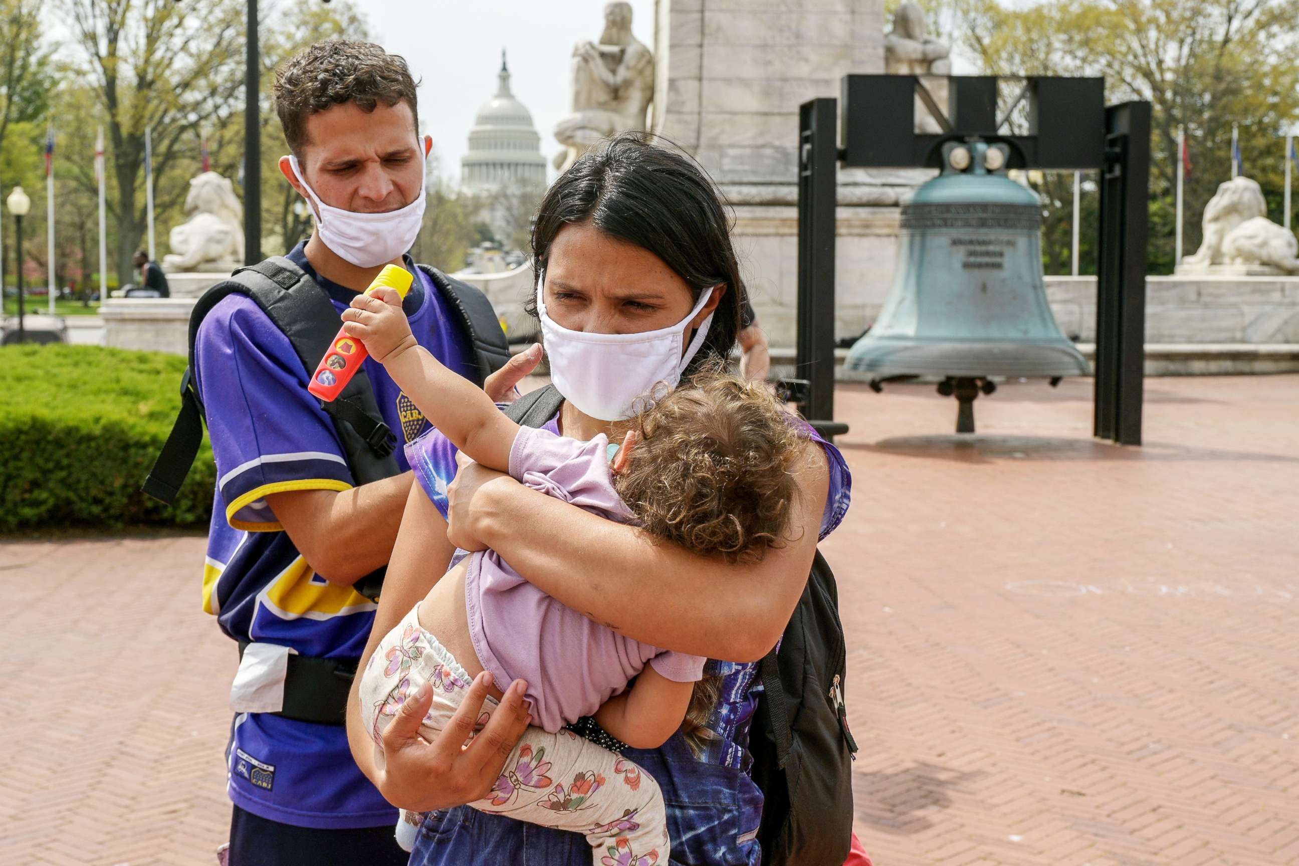 PHOTO: Ordalis Rodri­guez, 26, a migrant originally from Venezuela who was transported on a bus from Texas, holds her daughter Luciana, 1, as her husband Victor Rodri­guez, 27, looks on outside of Union Station in Washington, DC,  April 13, 2022. 
