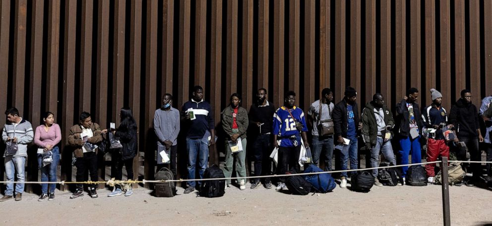 PHOTO: Migrants wait to be processed by Border Patrol agents after crossing illegally the border between the United States and Mexico, in Yuma, Ariz.., on May 10, 2023.