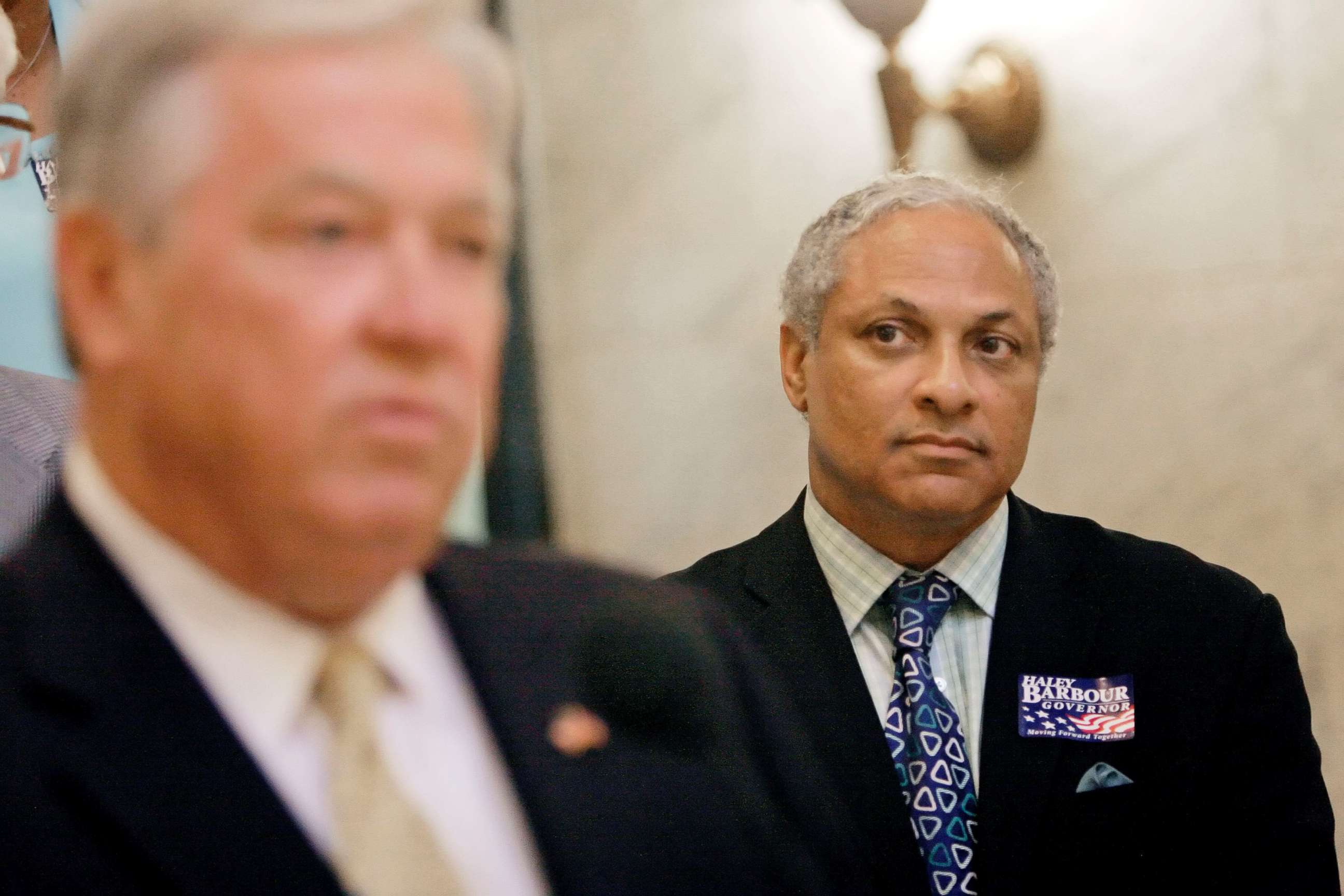 PHOTO: Mike Espy listens to Gov. Haley Barbour during a news conference, Wednesday, Oct. 17, 2007, at the Capitol in Jackson, Miss.