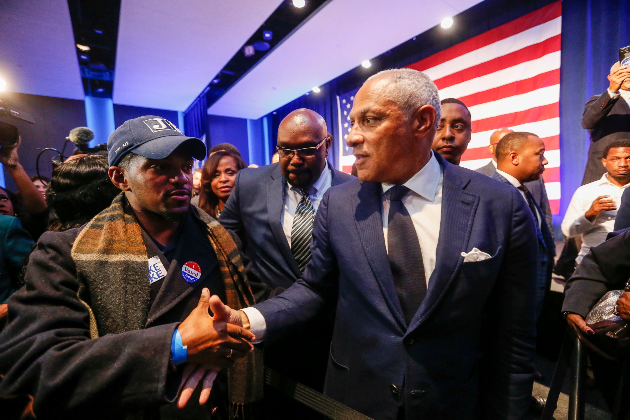 Democrat Mike Espy, right, who sought to unseat U.S. Sen. Cindy Hyde-Smith, R-Miss., shakes hands with a supporter in a crowded auditorium at the Mississippi Civil Rights Museum in Jackson, Miss., after losing the runoff election Tuesday, Nov. 27, 2018.