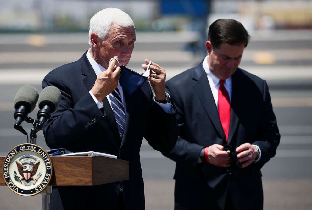 PHOTO: Vice President Mike Pence puts his face mask back on as Arizona Gov. Doug Ducey does the same after a news conference to discuss their meeting on the surge in coronavirus cases in Arizona, July 1, 2020, in Phoenix.
