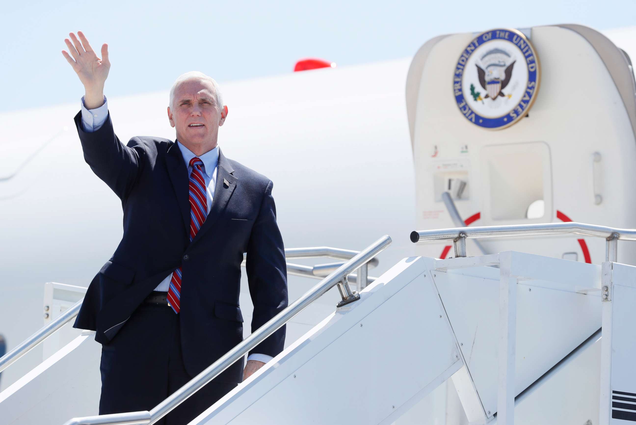 PHOTO: Vice President Mike Pence waves as he stops off Air Force Two after arriving at the Des Moines International Airport, May 8, 2020, in Des Moines, Iowa.