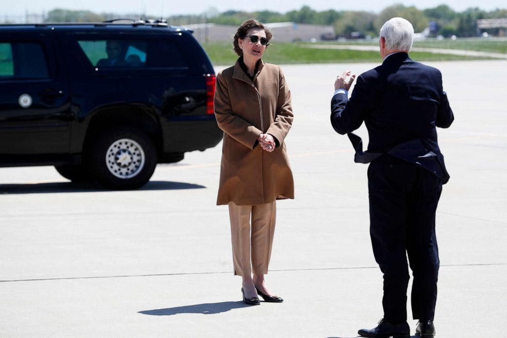 PHOTO: Vice President Mike Pence greets Iowa Gov. Kim Reynolds, left, after arriving at the Des Moines International Airport, May 8, 2020, in Des Moines, Iowa.